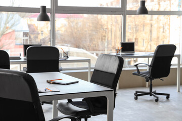 Tables, armchairs and stationery prepared for business meeting in stylish conference hall