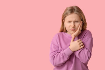 Young girl suffering from toothache on pink background