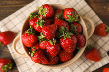 Bowl with sweet fresh strawberries on wooden background