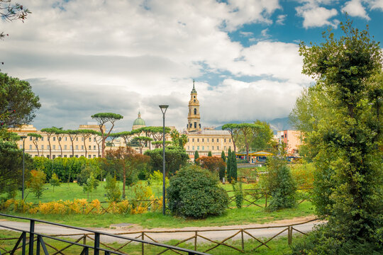 Green Park with Historical Buildings in Pompeii, Italy Under a Cloudy Sky