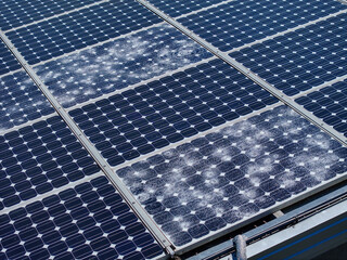 AERIAL, CLOSE UP: Cracked and shattered solar cells after severe hailstorm. Rooftop solar farm with reduced energy efficiency, vulnerability of renewable power systems to extreme weather conditions.