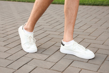 Man walking along paved road. Concept of new beginning