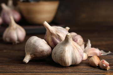 Many fresh garlic and cloves on wooden background