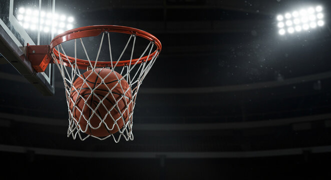Baloncesto. Pelota de baloncesto en el aro bajo un foco en una arena deportiva nocturna con espacio para texto, ideal para noticias deportivas, poster o banner
