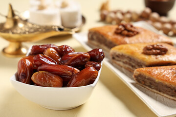 Sweet baklava and dates on beige background, closeup. Ramadan celebration