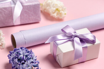 Lilac gift boxes with flowers and wrapping paper on pink background. International Women's Day