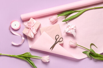 Gift boxes with tulips, wrapping paper and scissors on lilac background. International Women's Day