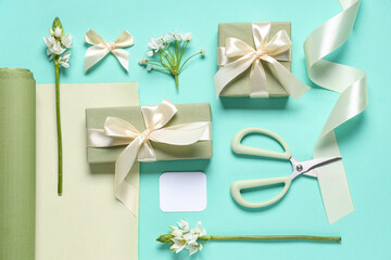 Gift boxes with flowers, wrapping paper and scissors on turquoise background. International Women's Day