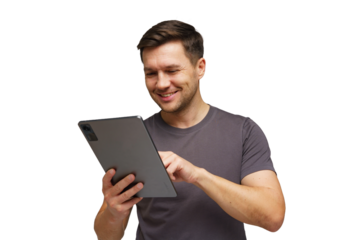 Young man smiling while using tablet in a bright setting, engaged in online activity