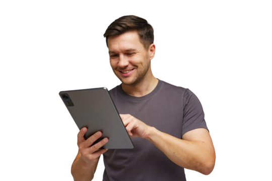 Young man smiling while using tablet in a bright setting, engaged in online activity