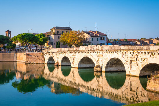 Famous Roman Bridge of Tiberius or Ponte di Tiberio in  historic center of Rimini, Italy at sunset