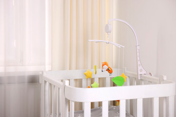 Cute baby mobile with crib in room