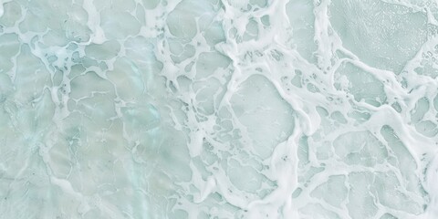 Obraz premium Aerial view of foamy turquoise ocean waves.