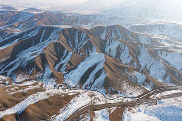 Aerial drone view of winding roads through a Martian-like winter landscape between Garni and Azat...