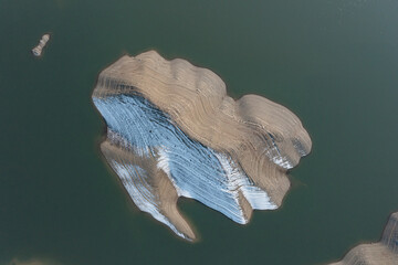 Aerial drone top down view of a small snow covered island in Azat Reservoir and near Garni, Armenia, in winter.  Stunning natural landscape great for travel and tourism