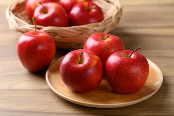 Red apple fruit (Gala apple) on wooden plate with wooden background
