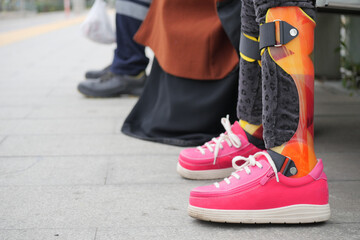 Close-Up of Pink Shoes and a Colorful Leg Brace for Mobility Support