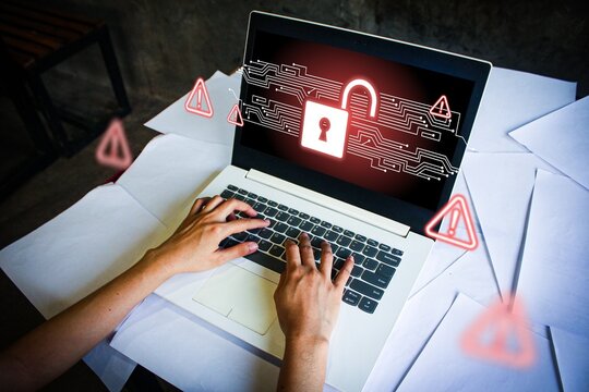 Cybercrime concept with a glowing unlocked padlock icon on a laptop screen. Digital security breach with warning symbols. Hacking, data theft, and cybersecurity risk illustration.