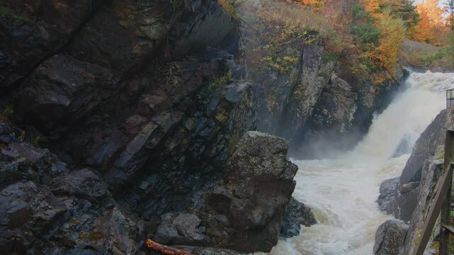 Experience the beauty of Gorge Creek flowing through High Falls Gorge in the Adirondacks. This footage captures the tranquil water surrounded by vibrant autumn foliage in a serene landscape.