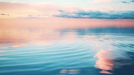 Obraz premium Gentle Ripples on a Calm Lake at Sunset with Soft Clouds