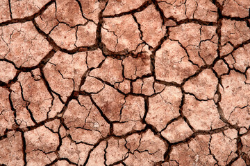 A striking view of red cracked ground, presenting a vivid texture that invites contemplation on the...