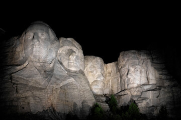 The iconic Mount Rushmore, beautifully illuminated during the night, showcasing the artistic...