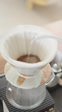 Vertical footage of pouring water on coffee grind as we call pour over coffee or Drip coffee.