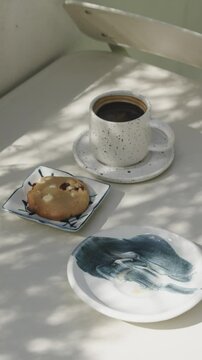 A cozy morning moment with a steaming cup of coffee and a crisp cookie, bathed in soft natural light.