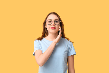 Young deaf mute woman using sign language on orange background