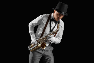 Male artist playing saxophone on black background