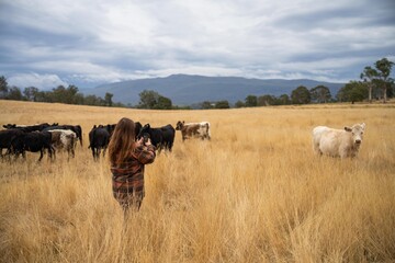 female regenerative organic farmer, taking soil samples and looking at plant growth in a farm. women in agriculture practicing sustainable agriculture good looking farmer