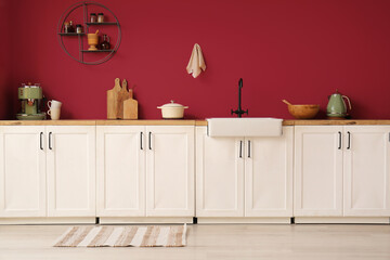 Counter, cooking utensils and sink in interior of stylish kitchen