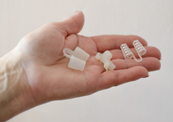 Hand holding anti-snoring device for nose. Selective focus.