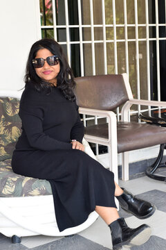 Indian woman in black dress posing for phtotgraph