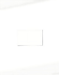 Blank white business card on a white background. Copy space.