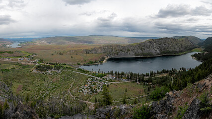 Obraz premium A breathtaking panoramic view showcasing serene valleys dotted with greenery and a tranquil lake, encapsulating the beauty and tranquility of nature in a gorgeous landscape.