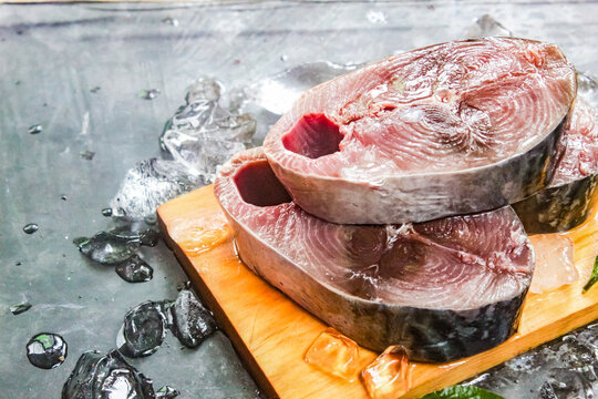 raw tuna pieces on a chopping board with ice