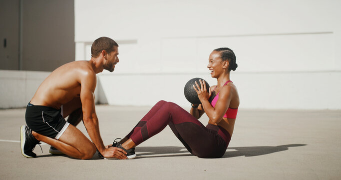 Outside, fitness or people with personal trainer for sit ups, workout or exercise for teamwork, health or strong core. Coach, woman or athlete with ball for balance, body training and six pack abs