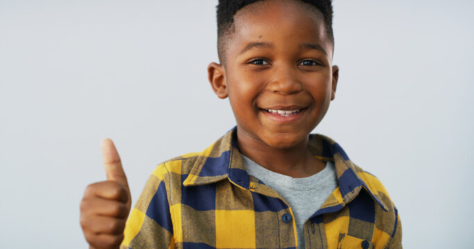 Portrait, smile and boy with thumbs up in studio of good news, positive feedback and agreement. Happy, black child and space with emoji of thank you, voting and approval of winner on white background