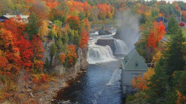 Stunning waterfall at Ausable Chasm in the Adirondacks, with autumn foliage framing the scene, showcasing the natural beauty of the region during peak fall season.