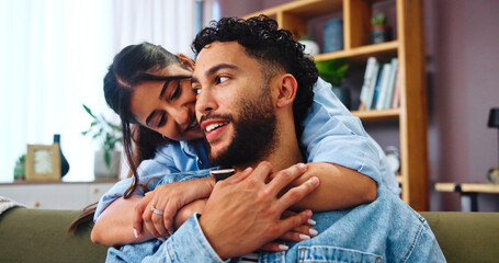 Home, hug and couple on sofa, love and bonding together with weekend break in lounge. Embrace, apartment and man with woman, calm and relax with romance, relationship and happiness with marriage