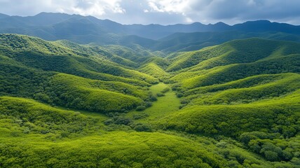 Obraz premium Aerial View of Lush Green Mountain Range Under Partly Cloudy Sky
