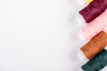 sewing Multicolored reels with threads lie on a white background. taken in close-up with space for...