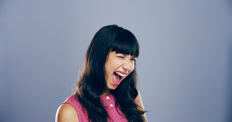 Woman, excited and face with wink in studio portrait, sign or emoji with secret, flirt and laugh by background. Person, model and smile with icon, win or eye symbol by space with confidence in Italy