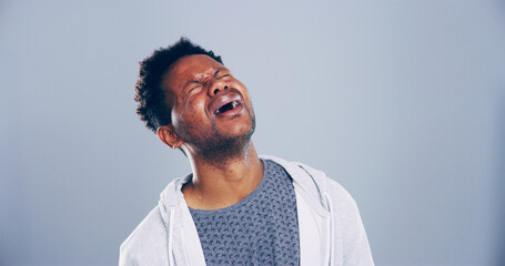 Obraz premium Grief, man and sad with crying in studio for broken heart, emotional and mourning loss. Mockup, black person and unhappy on gray background with sorrow, depression and pain from trauma or bad news