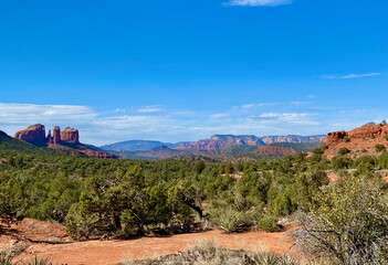 Naklejka premium A panoramic view of Sedona, Arizona, showcasing its famous red rock formations, desert landscape, and blue sky