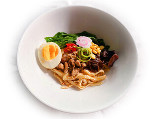Ramen noodle with chicken vegetables egg and mushroom on a white bowl