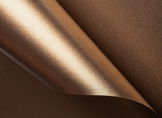 Gold and bronze paper background with a pearlescent, glossy texture and shimmering reflective...