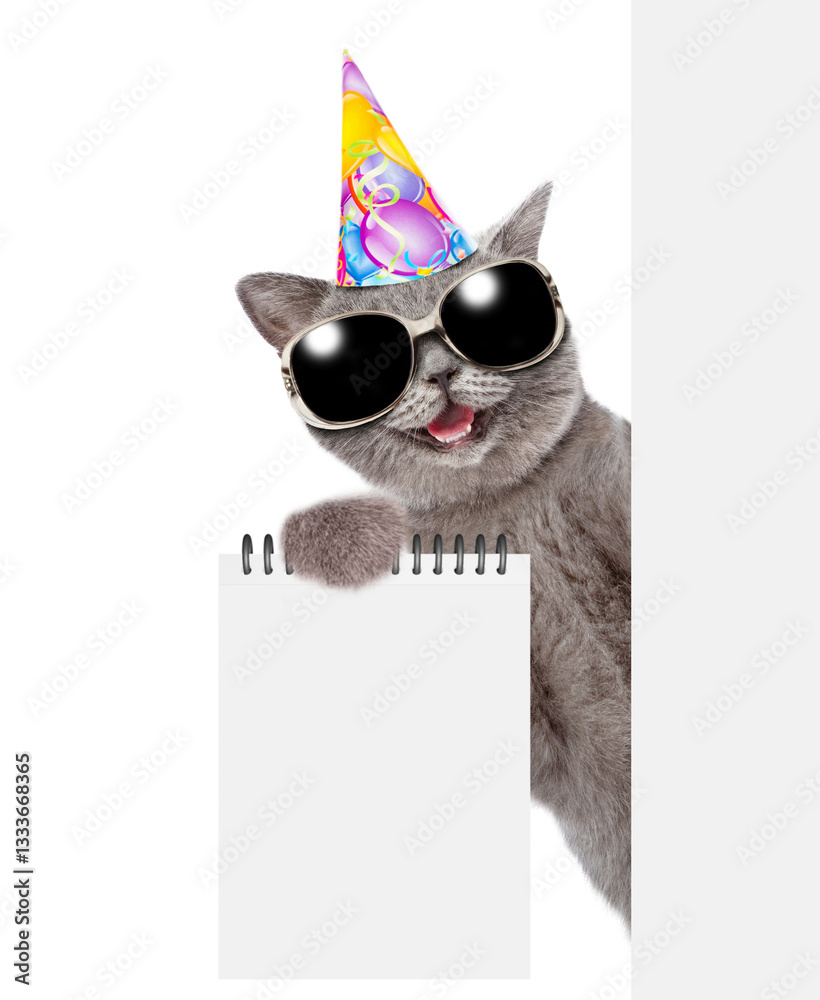 Aufkleber happy cat wearing party cap and sunglasses looks from behind blank white banner and shows blank note