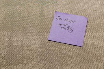 Thought-provoking message on a purple note resting on a textured surface